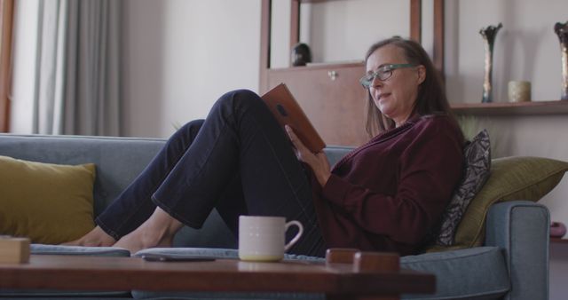 Woman Relaxing on Sofa Reading Tablet in Cozy Living Room - Download Free Stock Images Pikwizard.com