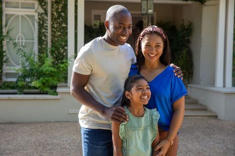 Smiling family posing together on sunny veranda