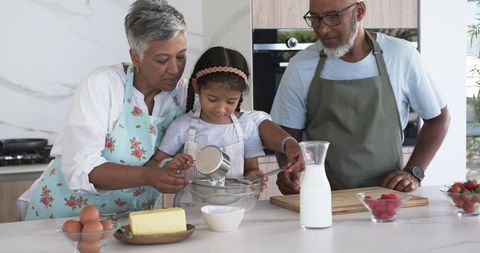 Grandparents Baking with Young Girl in Modern Kitchen for Leisure Activity