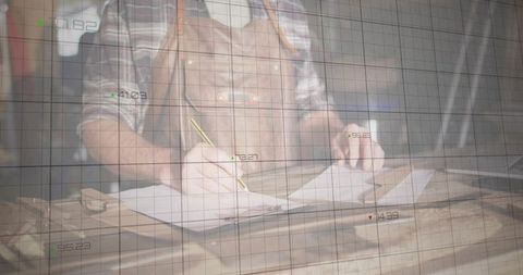 Craftsman drawing blueprint in workshop designing new project