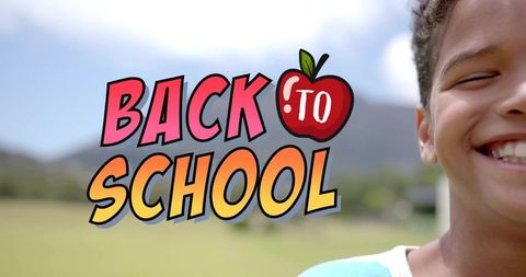 Back to school cheer smiling child wearing teal shirt outdoor field colorful apple graphic