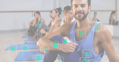Smiling fit man leading mindful group yoga class with sustainability icons overlay