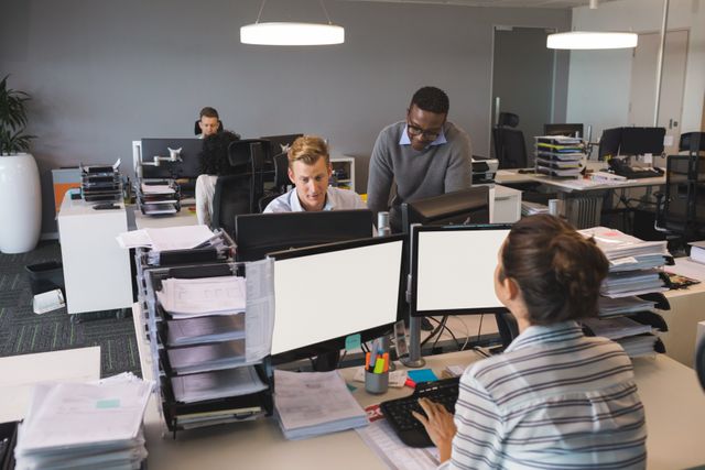 Colleagues work together in a modern corporate office environment. Ideal for illustrating teamwork, productivity, office culture, professional settings, or collaborative work environments.