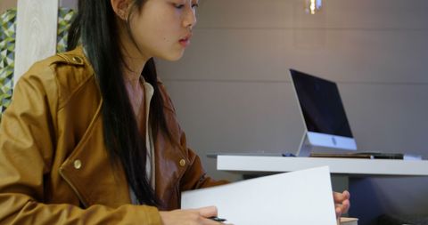 Businesswoman analyzing documents at modern office desk