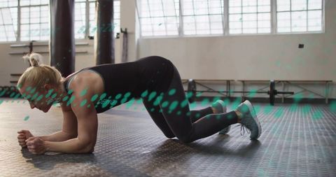 Female athlete performing modified forearm plank on gym floor core strength training