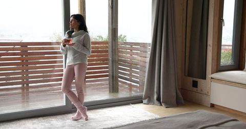 Young Woman Enjoying Cozy Morning Indoors with a View