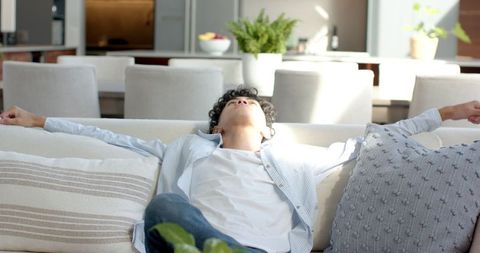 Man Relaxing on Sofa in Bright Modern Living Room