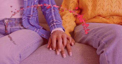 Diverse Couple Holding Hands With Heart Graphics Indoors