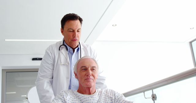 Doctor attending to senior patient in hospital wheelchair, showing care and compassion. This image can be used in healthcare advertisements, medical brochures, elderly care services, hospital websites, and patient care campaigns.