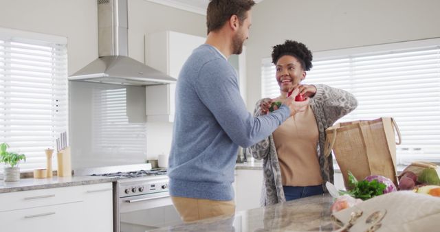 Image of happy diverse couple unpacking groceries in kitchen - Download Free Stock Photos Pikwizard.com