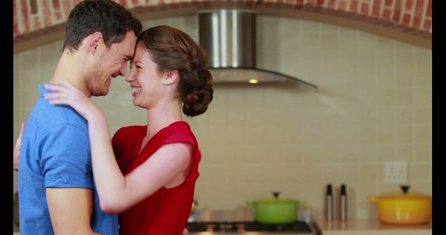 Happy young couple embracing together in the kitchen