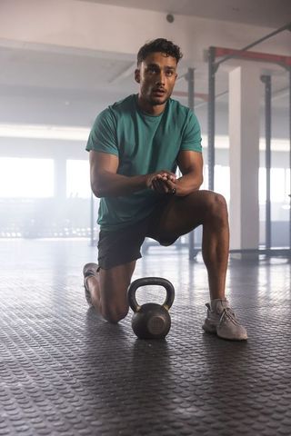 Athletic Man Resting Arming Rig After Intense Kettlebell Workout
