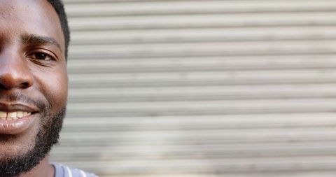 Close-Up of Smiling Young Man Against Blurred Striped Background
