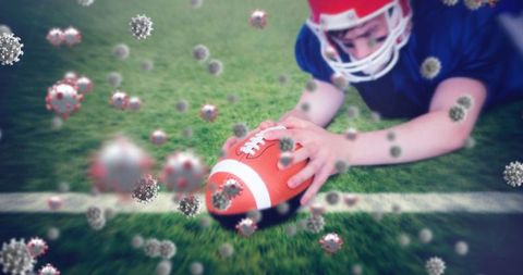 Athlete in Helmet Reaching For Football Covered In Virus Particles