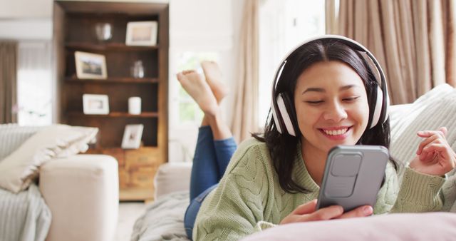 Young Woman in Green Sweater Relaxing with Headphones and Smartphone at Home - Download Free Stock Images Pikwizard.com