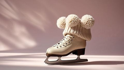 Elegantly cozy figure skate with pompom hat on soft pastel ice skating background