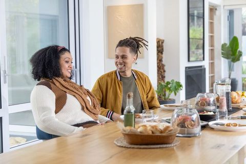African american couple chatting at sunlit modern dining table with woven bread basket