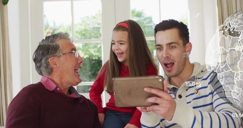 Multigenerational family watching tablet together in sunlit living room with ar globe
