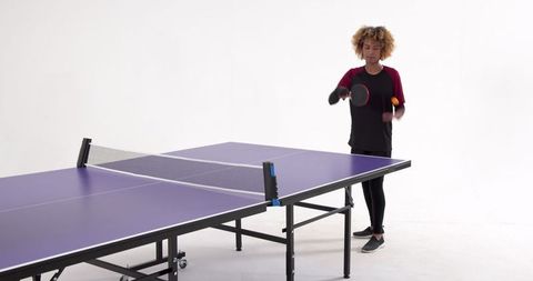 Athletic Woman Practicing Ping Pong Skills Focused on Techniques
