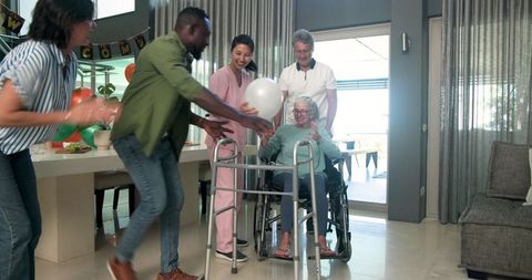 Diverse Group Welcoming New Elderly Patient in Rehabilitation Center