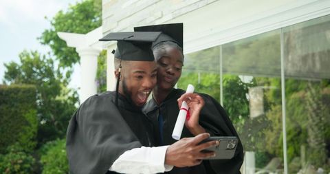 Excited Graduates Capturing Memories With Diplomas Outdoors