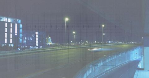 Stretching empty urban freeway with neon light trails and concrete barrier at night