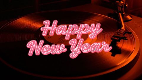 Neon happy new year on spinning vinyl turntable with retro pink glow
