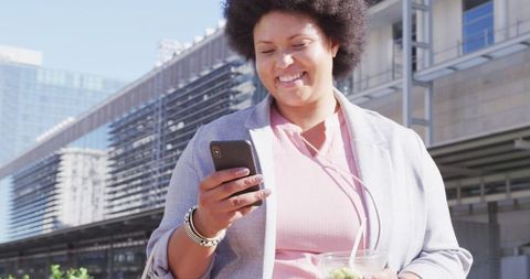 Smiling Plus Size Woman Engaging with Smartphone Outdoors