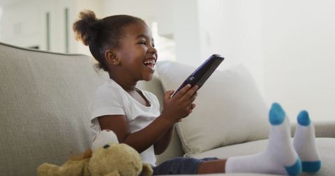 Joyful Girl Watching TV on Couch Indoors - Download Free Stock Images Pikwizard.com
