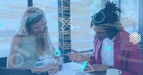 Young designers collaborating over blueprints and tablet with augmented code overlay