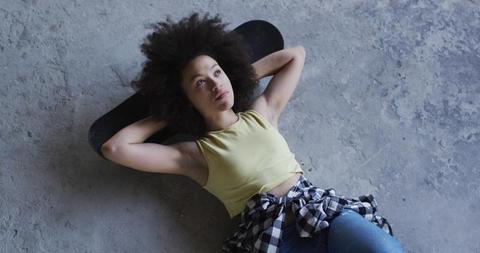 Woman Relaxing on Skateboard on Concrete Ground - Download Free Stock Images Pikwizard.com