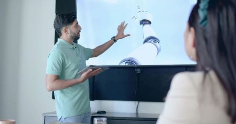 Businessman Pointing at Robot Arm Presentation in Meeting