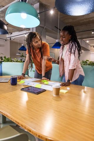 African american coworkers collaborating over project plans in modern coworking space