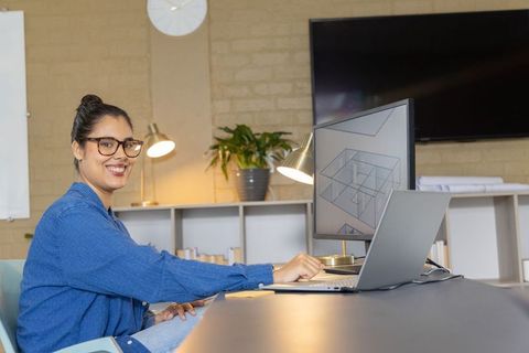 Architect reviewing 3d floor plan on monitor while working at modern studio desk