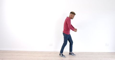 Young man in red sweater performing an energetic dance move
