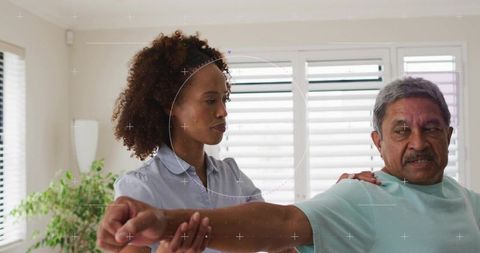 Caregiver guiding senior through assisted arm stretch at home for gentle mobility therapy