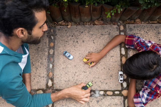 High angle view of father and son playing with toy car in yard