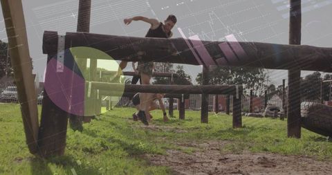 Male Athlete Leaping Over Wooden Beam During Outdoor Obstacle Course Training Session