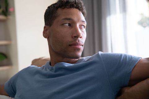 Thoughtful Man Relaxing Near Window in Modern Living Room