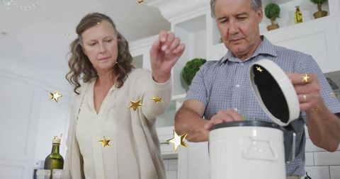 Mature Couple Preparing Meal with Seasoning in Modern Kitchen