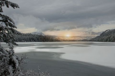 Tranquil Winter Landscape with Frozen Lake at Sunrise