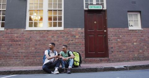 Two Biracial Friends Enjoying City Break Discussing Travel Plans