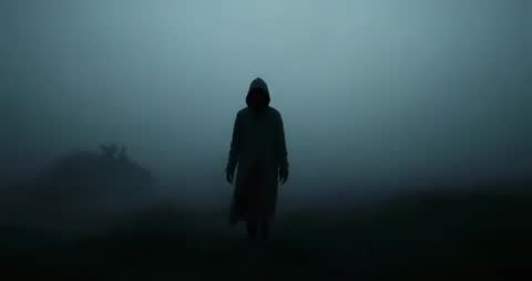 Mysterious Hooded Figure Walking Through Foggy Landscape