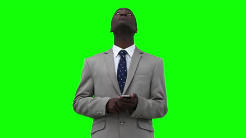 Businessman in Suit Looking Up While Using Smartphone