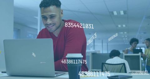 Focused Man Working on Laptop with Data Holograms in Office
