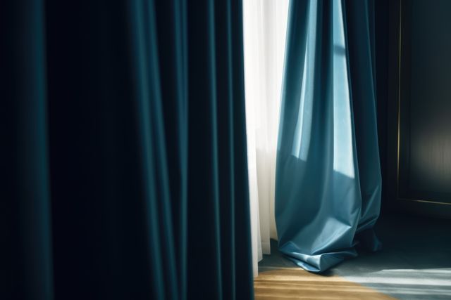 Blue curtains hanging in room with window, created using generative ai technology. Interior design, home decor and fabric concept digitally generated image.