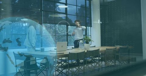 Business team collaborating in glass boardroom with laptop smartphone reflections and globe overlay