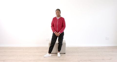 Confident Woman in Stylish Red Jacket Posing on Stool - Download Free Stock Images Pikwizard.com