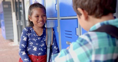 Two Schoolchildren Chatting by Lockers in Slow Motion