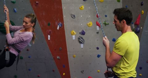 Couple enjoying indoor rock climbing at adventure gym